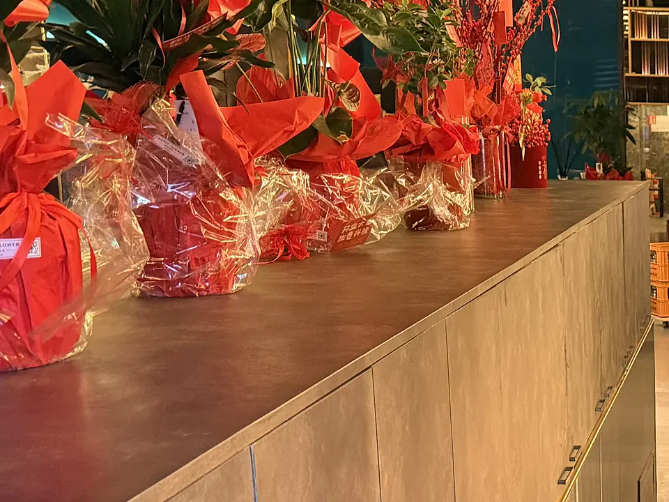 Wrapped red flower arrangements on the long cabinet in the entrance