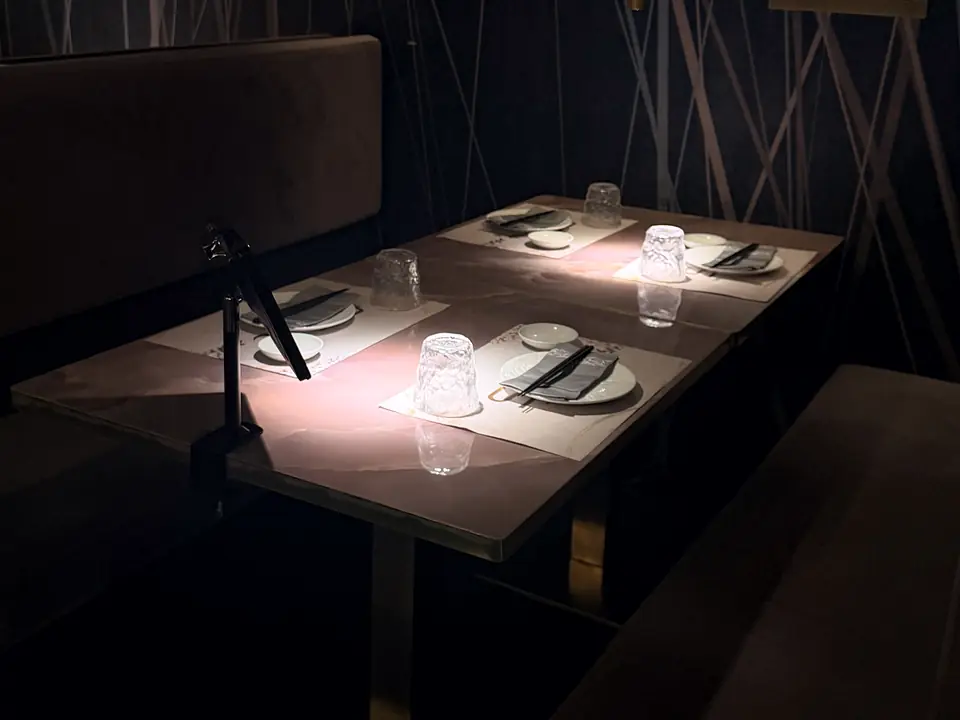A table set for four in a booth, in soft low light